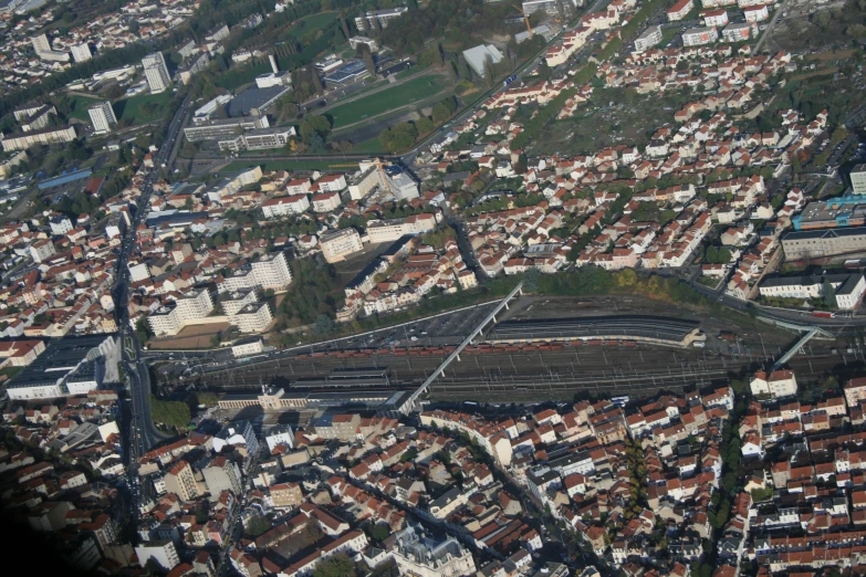 aerial view of buildings in a neighborhood, with a train track running through the center