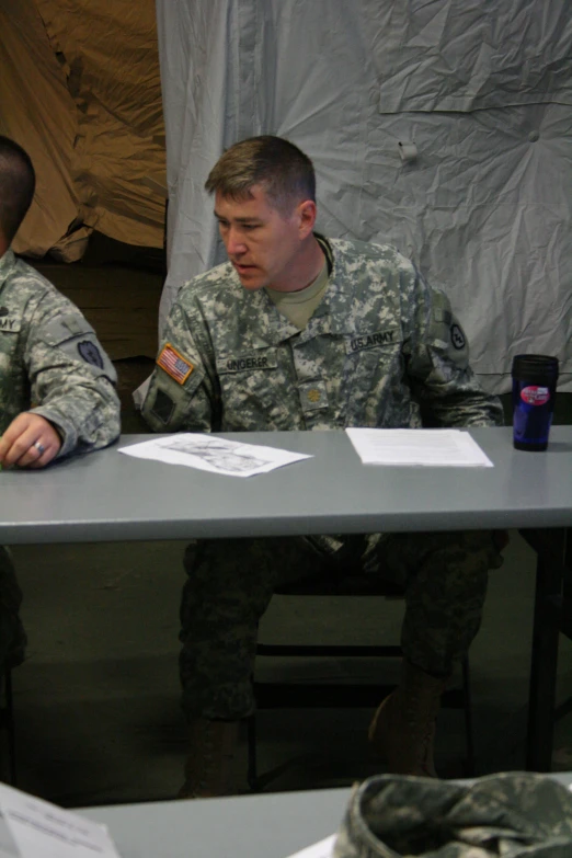 a couple of soldiers siting at a table