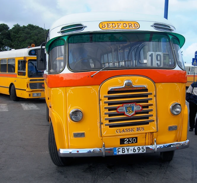 two old buses are parked at an event