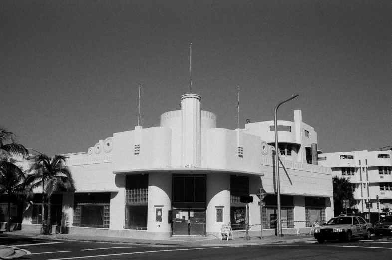 the building has a white tower and two cars in front