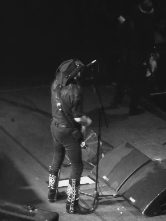 a person in boots holding an umbrella while on stage