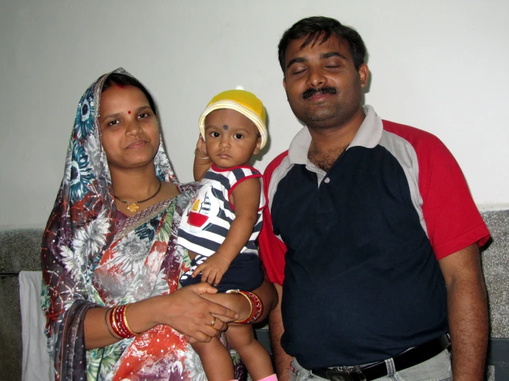 a man and woman standing next to each other with a baby