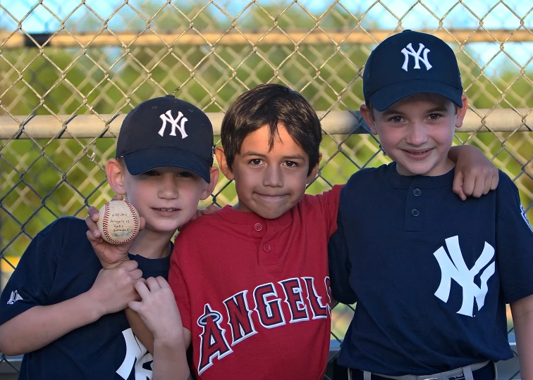 three boys with baseball caps and a ball