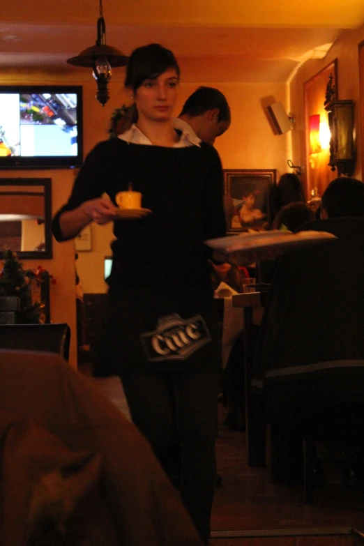 a woman stands in a living room while holding an ice cream bar