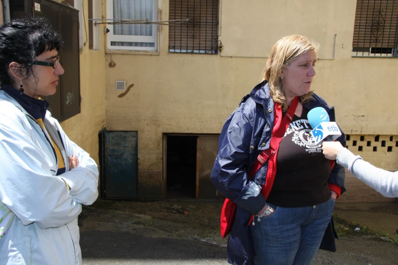 two women standing next to each other talking