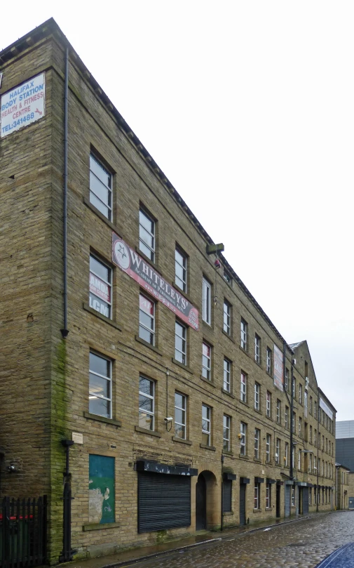 a brick building sits on a cobble stone street