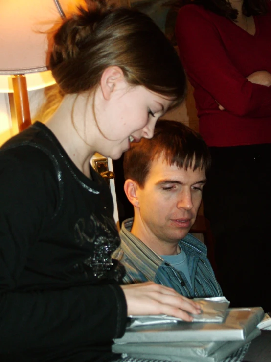 the girl looks at her man's tablet as he looks down