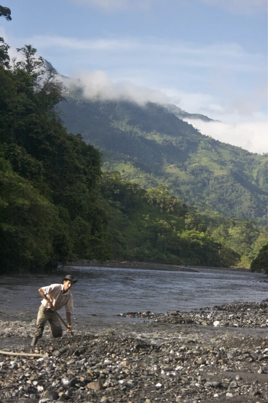 two men are digging for soing in the river