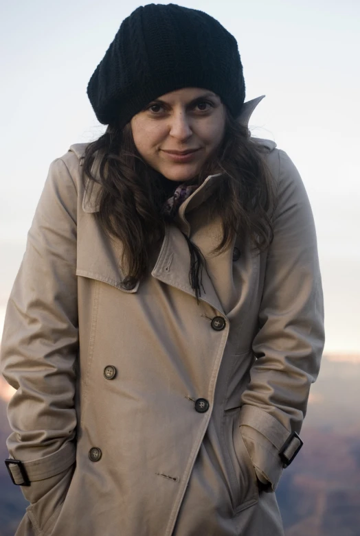 a woman wearing a black hat poses for the camera