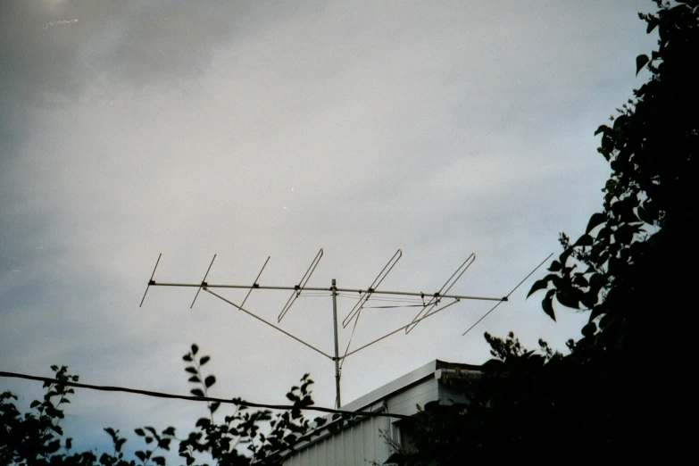 an antenna on top of a roof by some trees