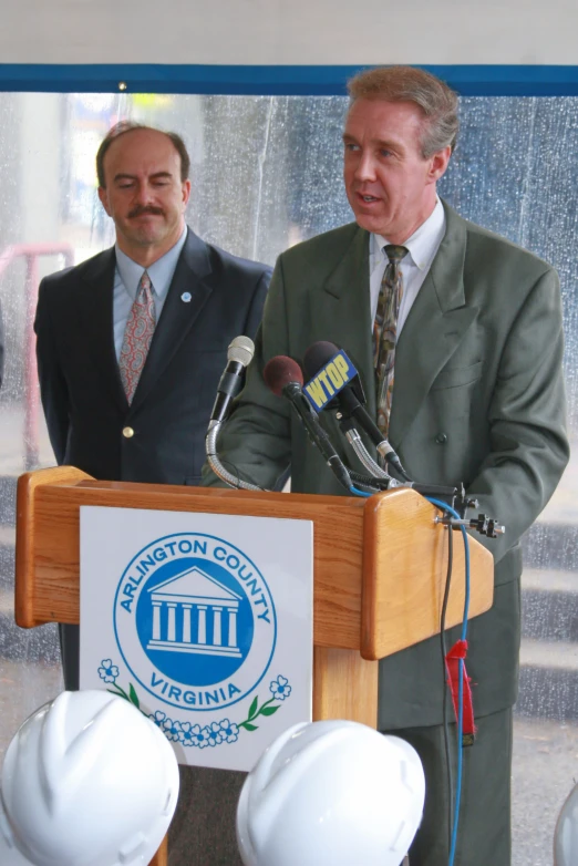 two men standing behind a podium talking