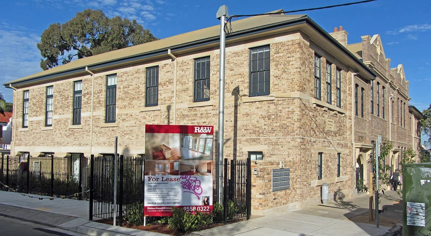 a tall brick building with a poster on it