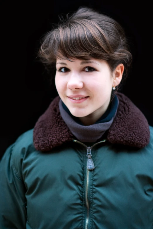 a woman in a green jacket and jacket smiling