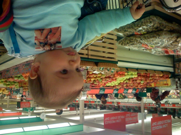 an image of baby in shopping basket at market