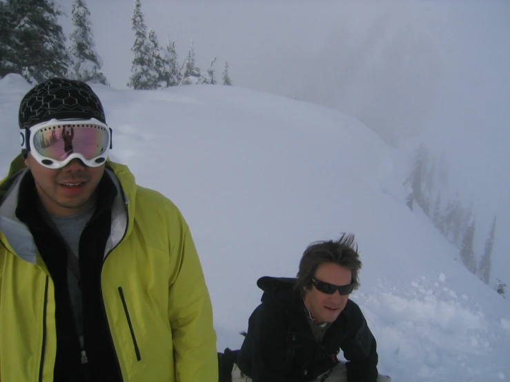 two people walking up a snowy hill in snow goggles