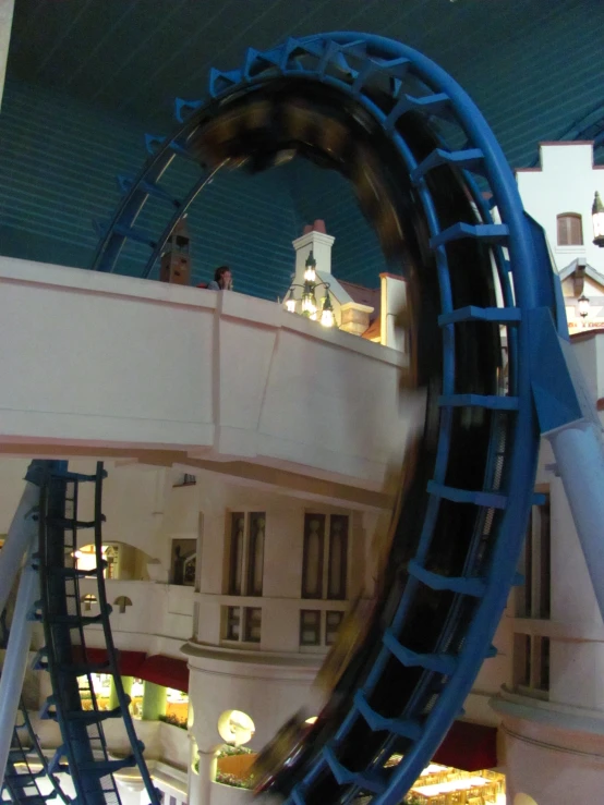 a roller coaster suspended over an indoor mall