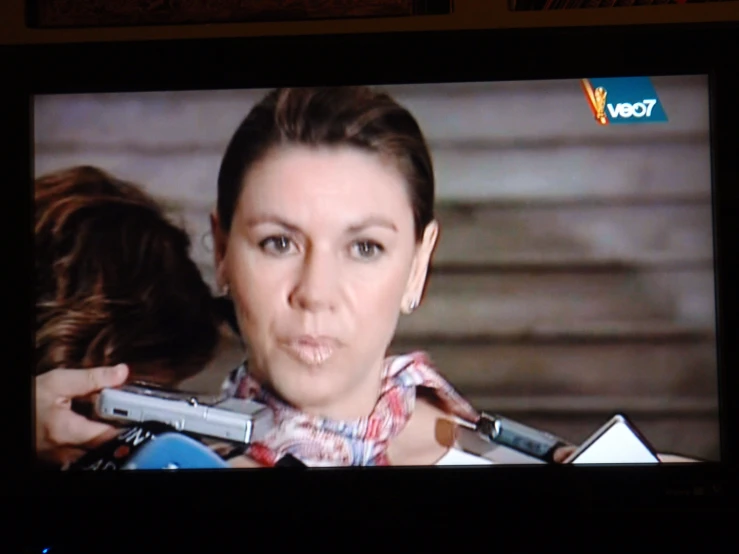 a tv showing a picture of a woman being attacked by a gun