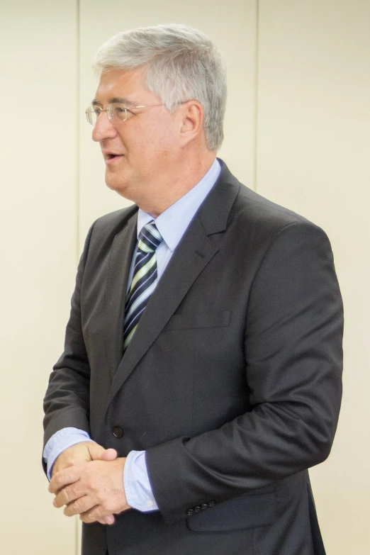 a man with grey hair is wearing glasses and a suit