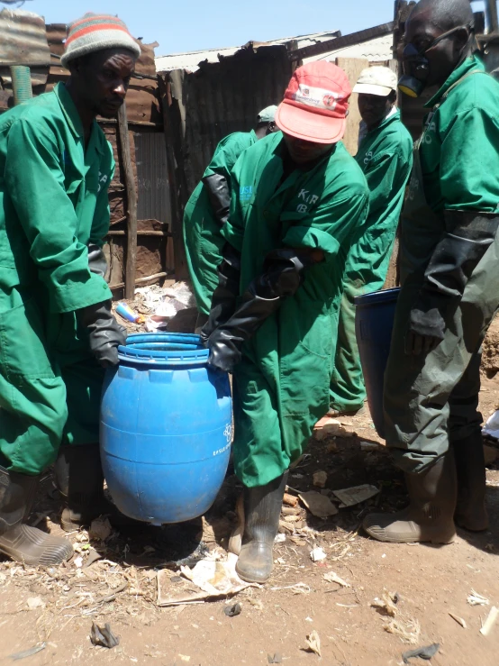 a group of people wearing green and hats with a water tank