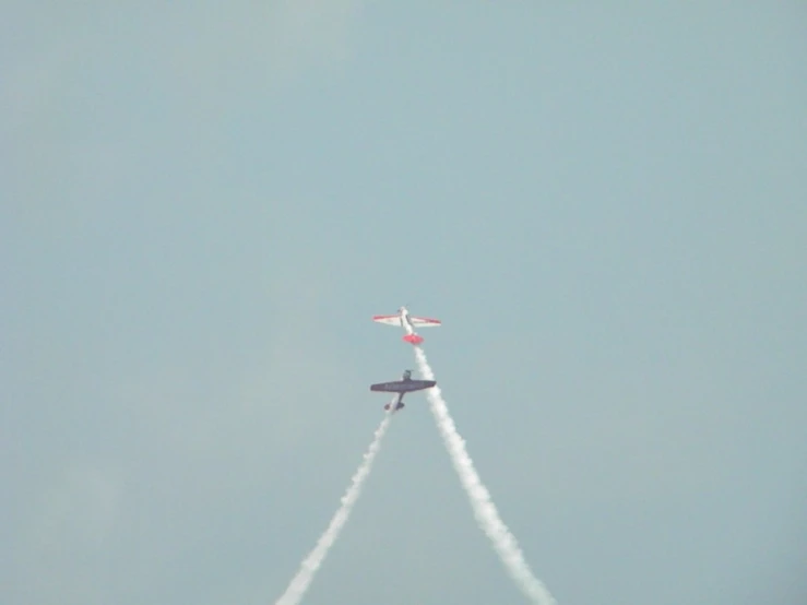 two airplanes in the sky during an airshow