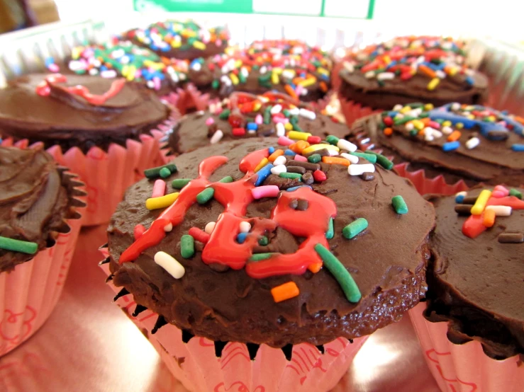 cupcakes that are decorated with chocolate frosting and sprinkles