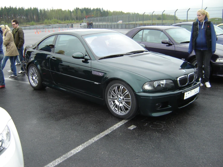 there is a dark green bmw in the parking lot