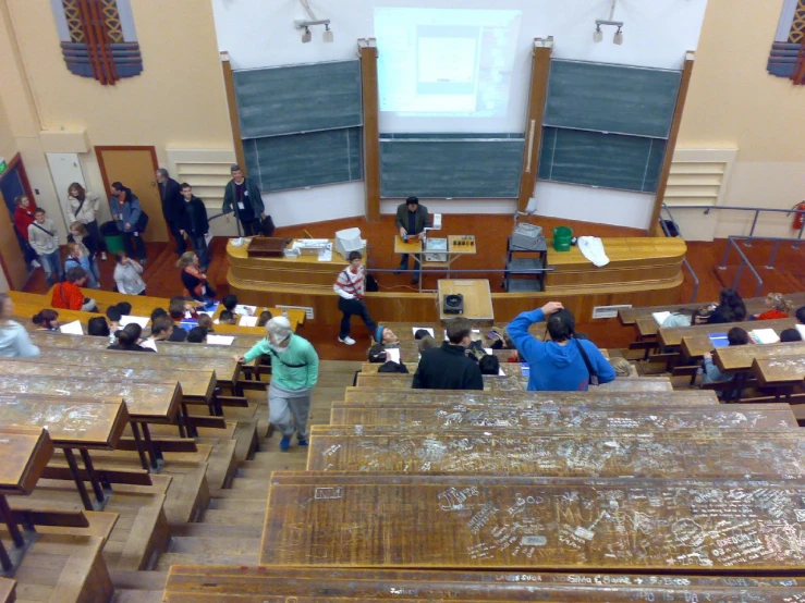 two students stand at the microphone at a lecture hall