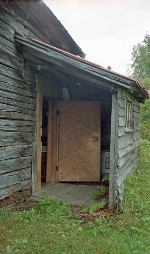 a shack sitting in the middle of a grassy area