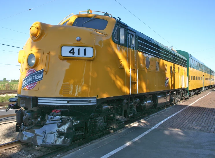 the large yellow train is parked near the side of the road