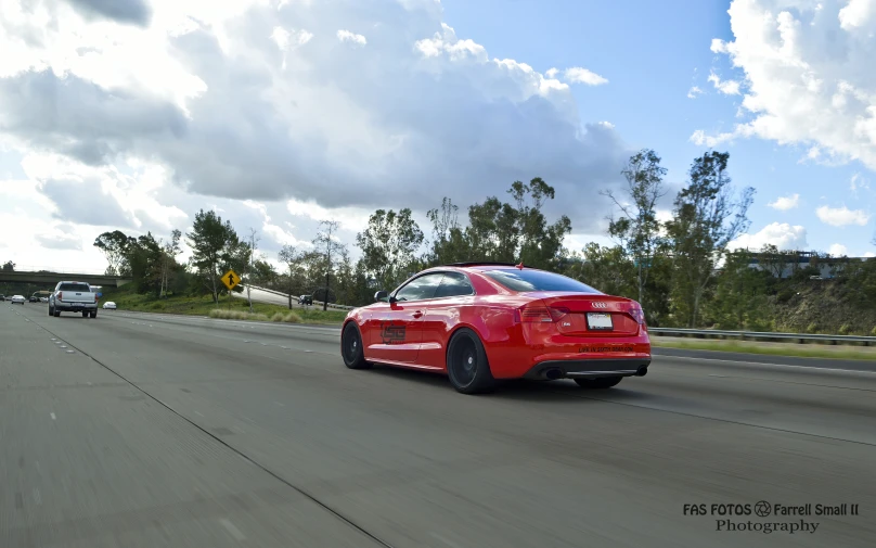 a red sports car driving down the street