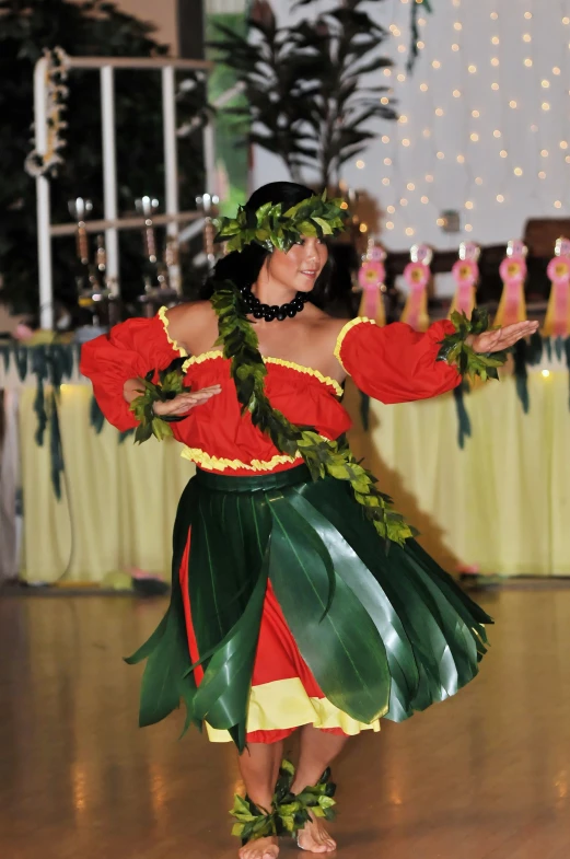 a beautiful young woman dancing in a leaf print skirt