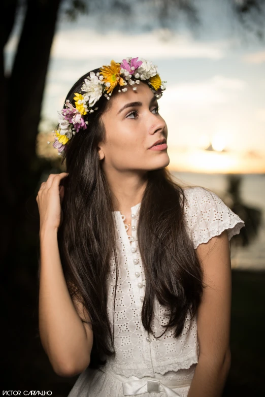 a woman wearing a flower crown with her hair in a pony tail
