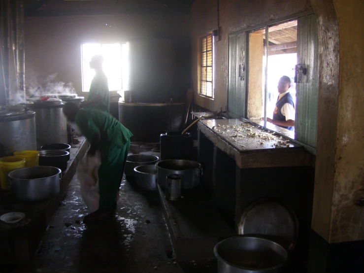 woman cooking in a large kitchen filled with pots