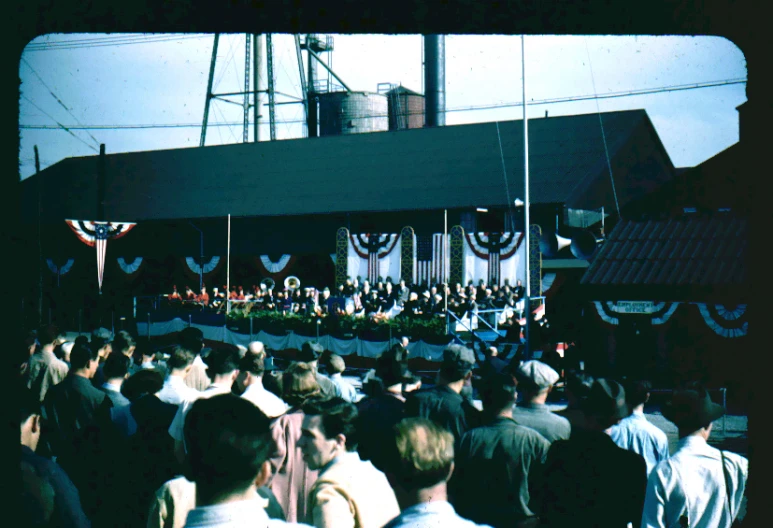 large crowd watching people on stage in outdoor event