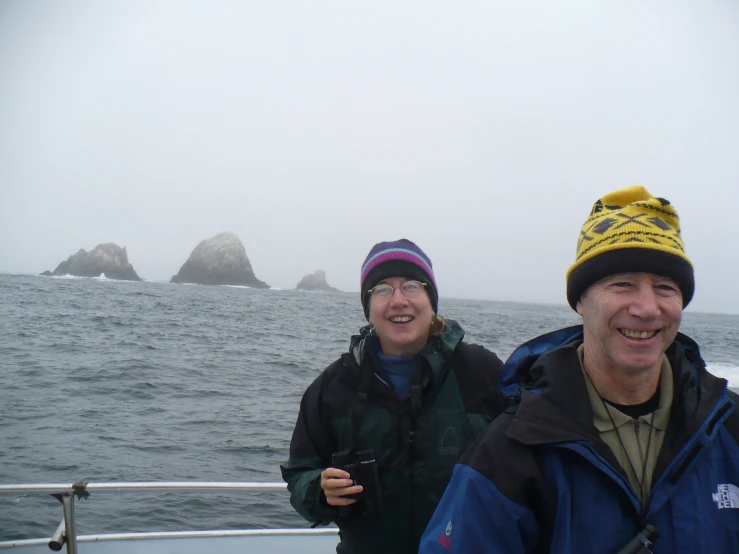 two people standing on a boat in the water