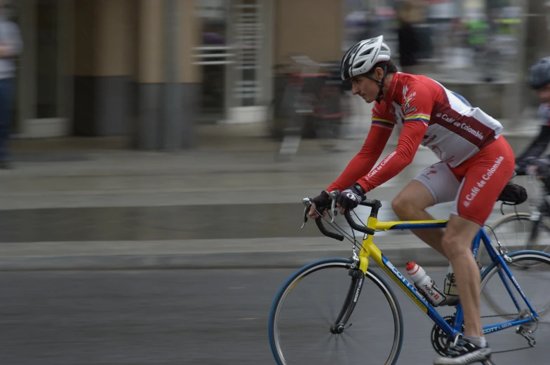 a cyclist rides along the road near many other people