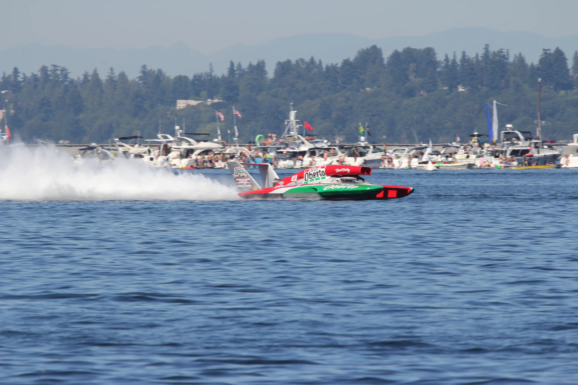 a speed boat traveling in a lake with water spray