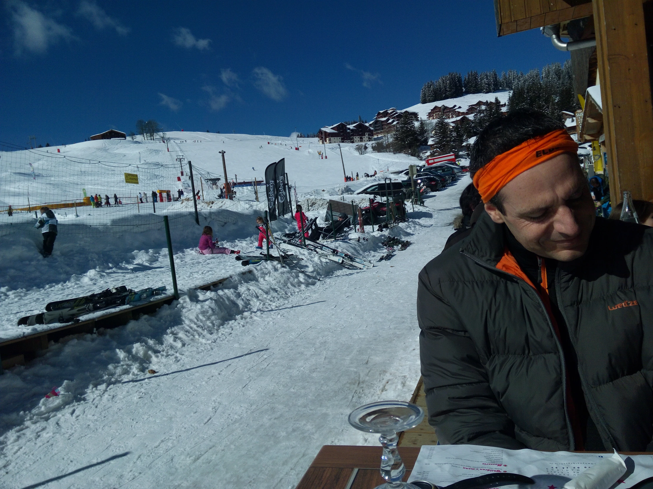 a man in a head scarf sitting at a table outside