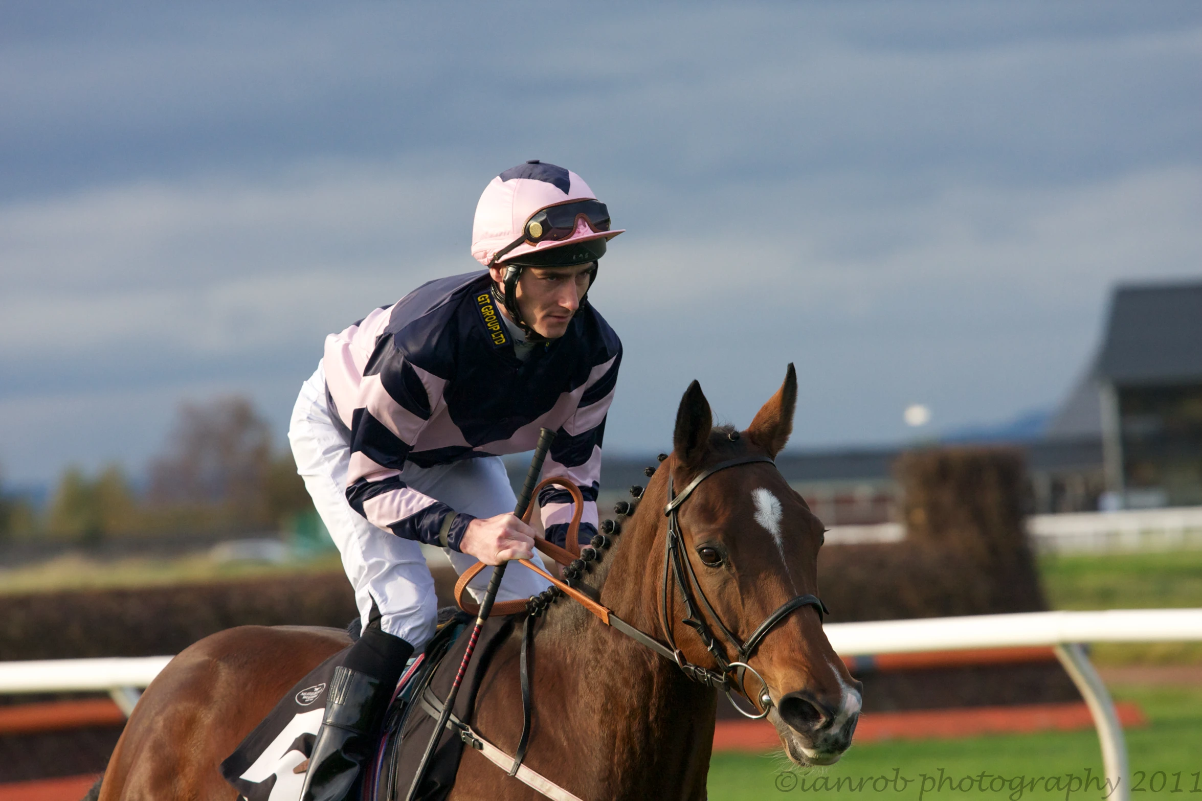 the jockey is riding the horse down the track