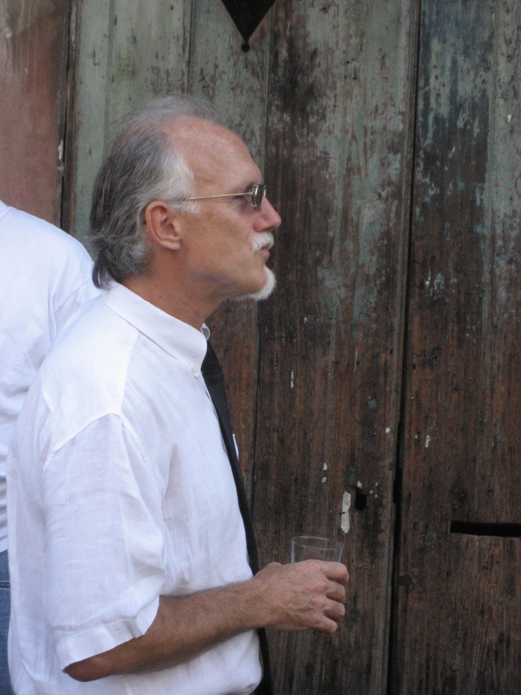 a man wearing sunglasses is holding a drink in his hands