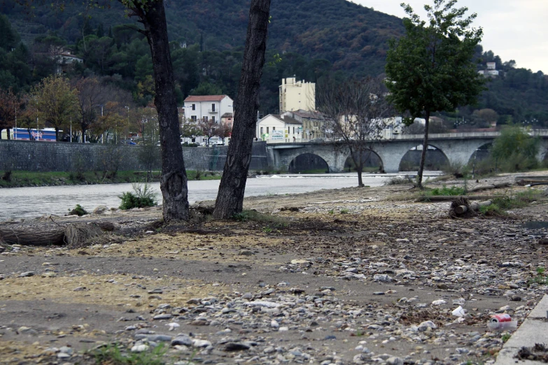 a road near a river with rocks and trees