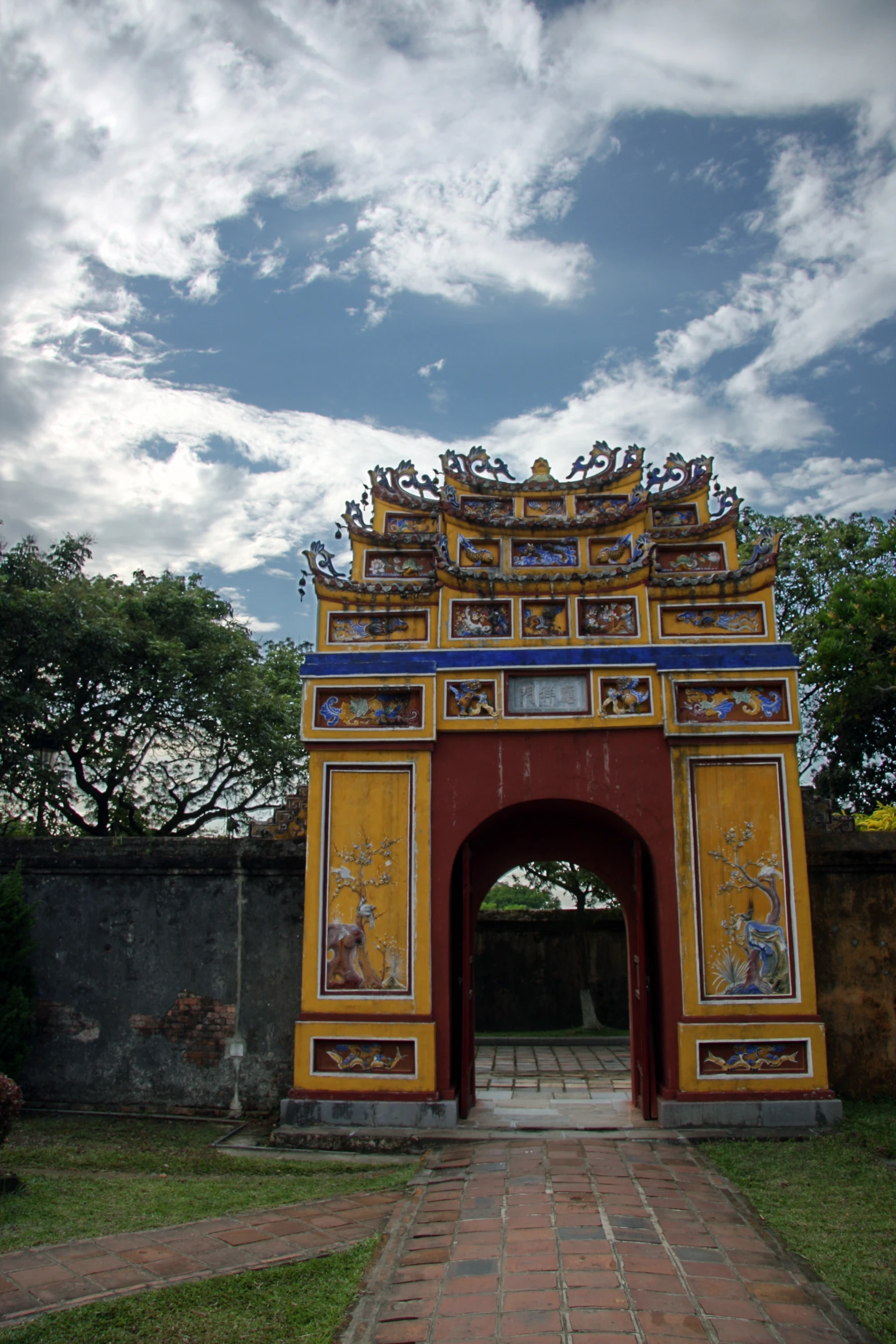 a yellow and blue arch at the entrance to an outside park