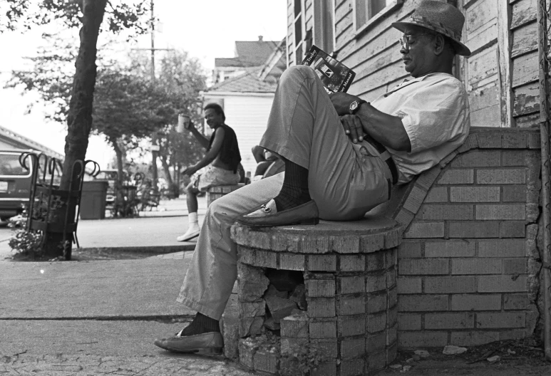 man playing a guitar outside his old home