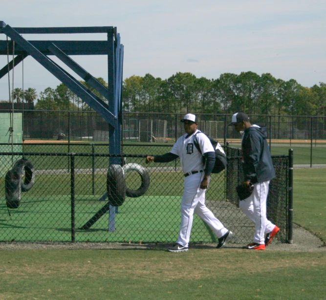 two men are walking on a baseball field