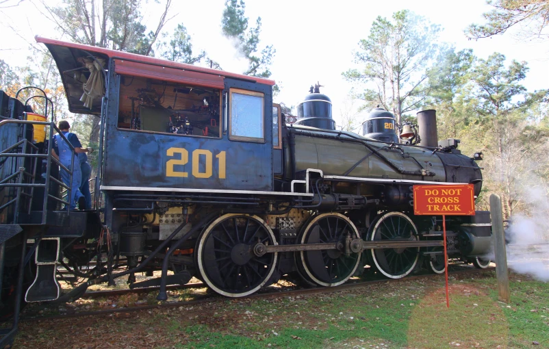 a locomotive train sitting on a track with smoke coming from it