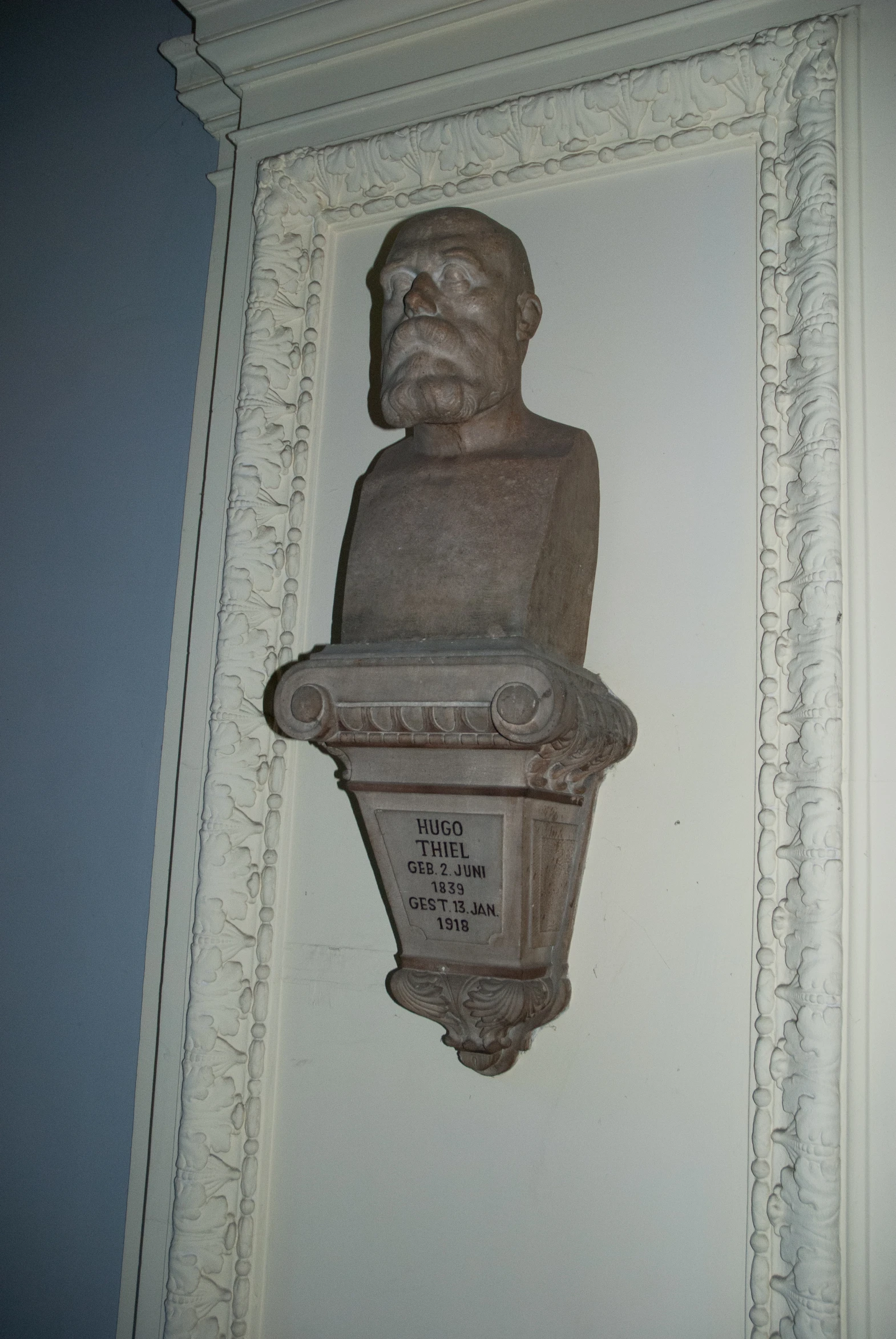 an old man statue sits in the corner of a room