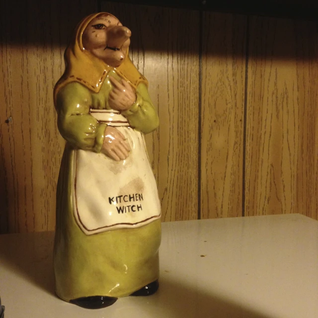 a ceramic statue with a brown scarf on it's head