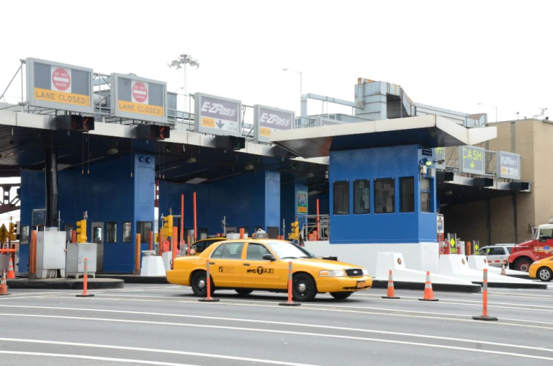 a yellow taxi is parked at a toll booth