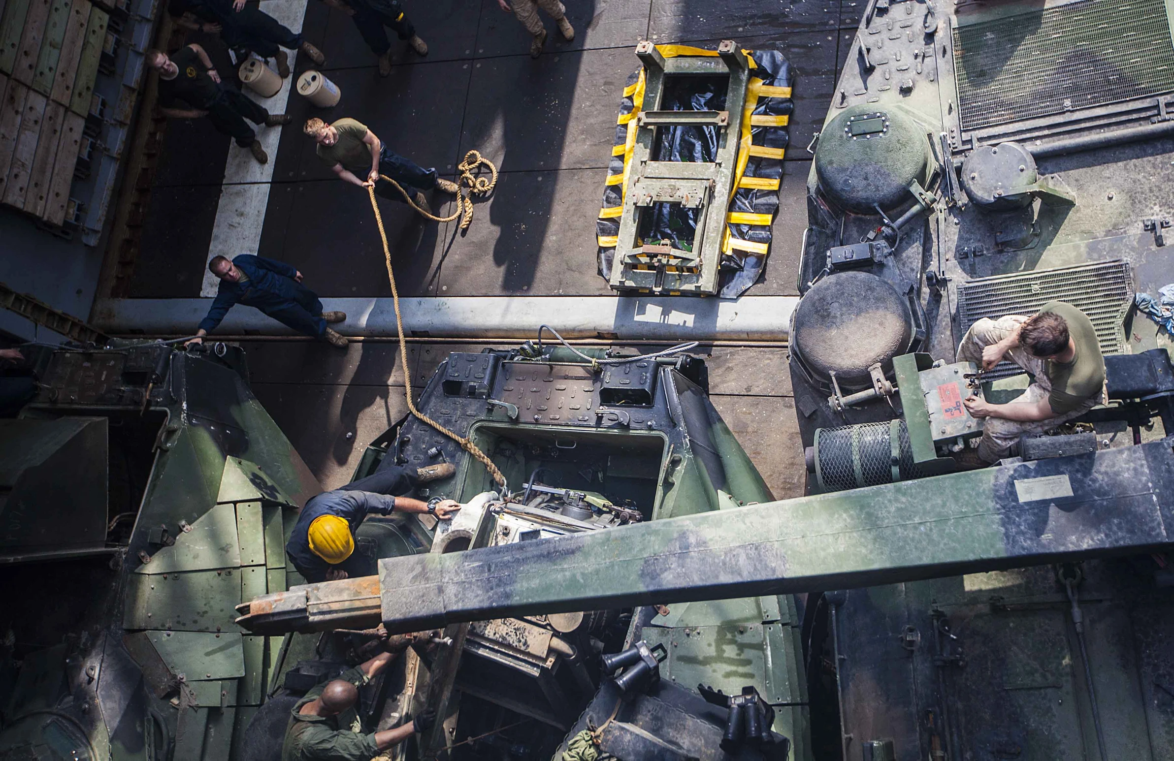 an aerial s shows military vehicles in the foreground and soldiers standing on the deck