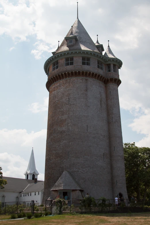 an elaborate tall brick tower with steeples and arched windows